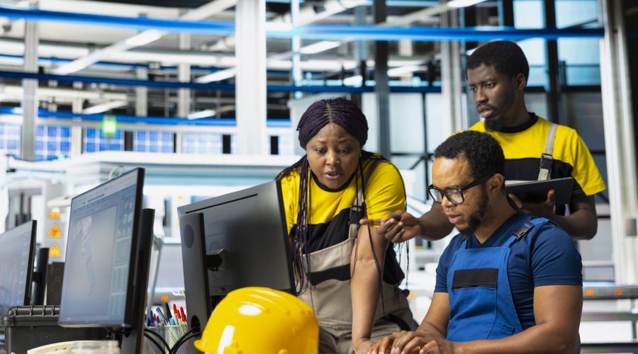 Black team of manufacturing plant employees fixing errors and debugging technical issues, working together in the assembly line of solar panels at the industrial factory. Renewable energy.